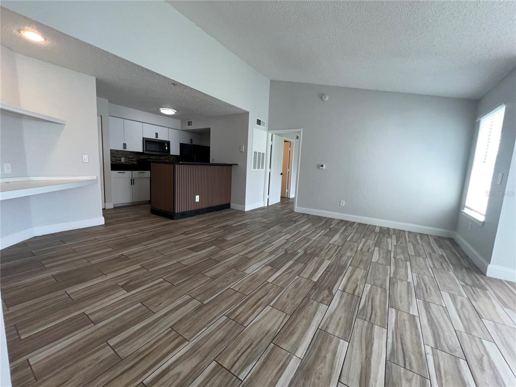 A bathroom features a shower-tub combination, a white toilet, and a vanity with black countertops — 2208 ANTIGUA PLACE UNIT 938, KISSIMMEE, FL