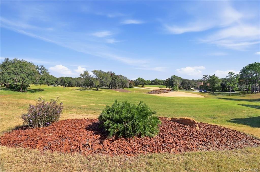 A view of a golf course fairway with a landscaped garden bed in the foreground — 2618 N CARNOUSTIE LOOP, LECANTO, FL