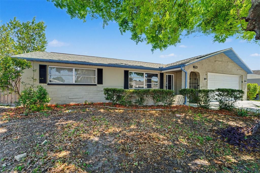 A single-story house with a beige exterior, stone facade, and a two-car garage — 7744 WATERFORD STREET, NEW PORT RICHEY, FL