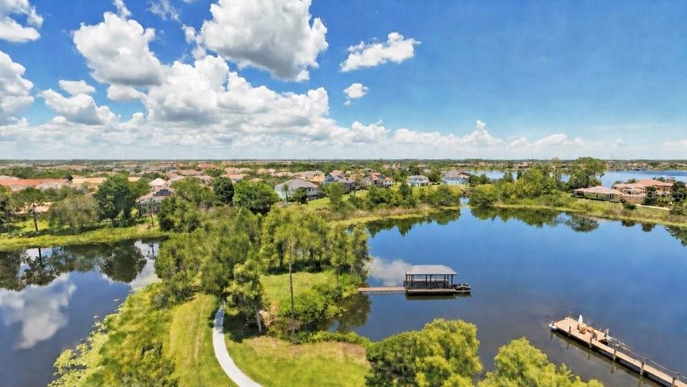 An aerial view shows a lake with a wooden dock and a covered boat slip — 8342 BOYLA COURT, WINDERMERE, FL