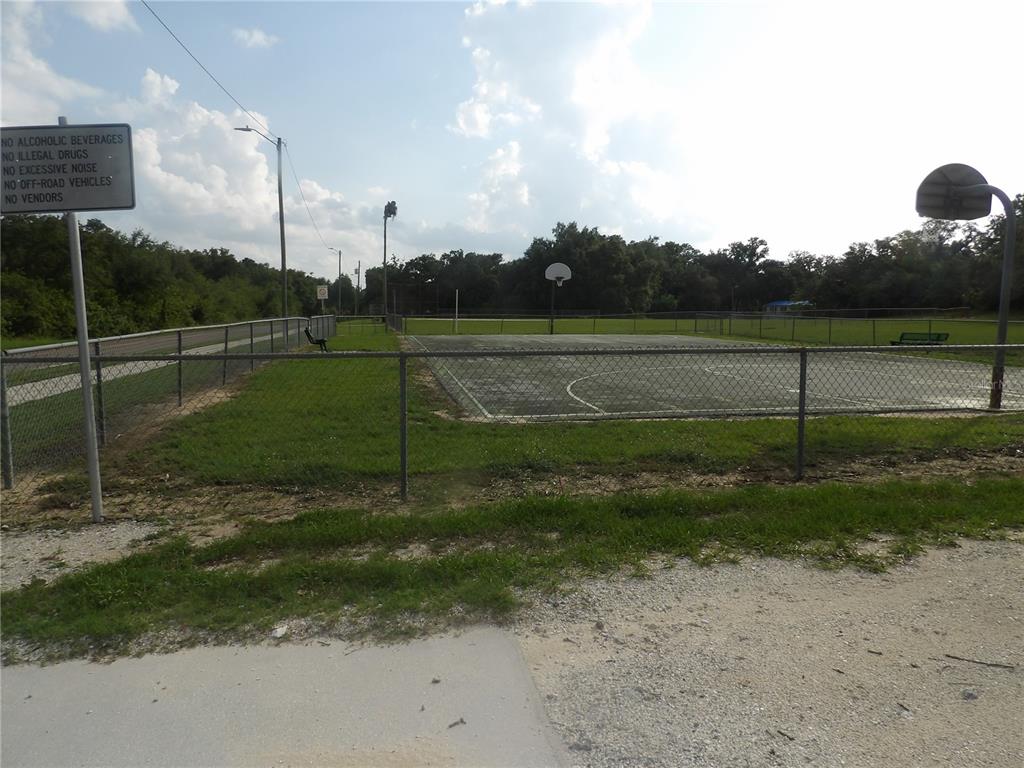 An outdoor basketball court is enclosed by a chain-link fence near a park sign — 2817 RICHARDSON ROAD, BARTOW, FL