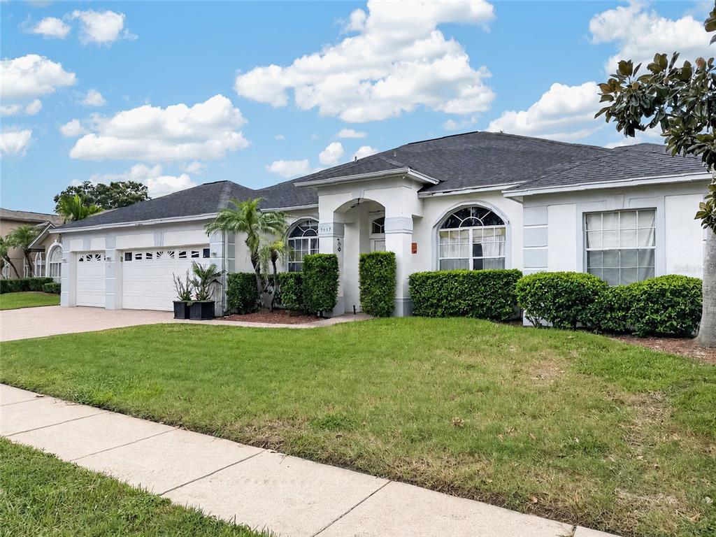 A single-story house with a white stucco exterior, arched windows, and a two-car garage — 3637 DEVEREAUX COURT, ORLANDO, FL
