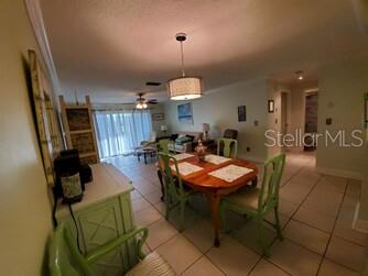 A dining area with a wooden table and green chairs sits near a living room — 2100 OCEAN SHORE BOULEVARD UNIT 3170, ORMOND BEACH, FL