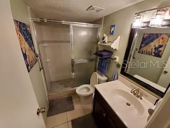 A bathroom features a walk-in shower, a toilet, and a vanity with a mirror — 2100 OCEAN SHORE BOULEVARD UNIT 3170, ORMOND BEACH, FL