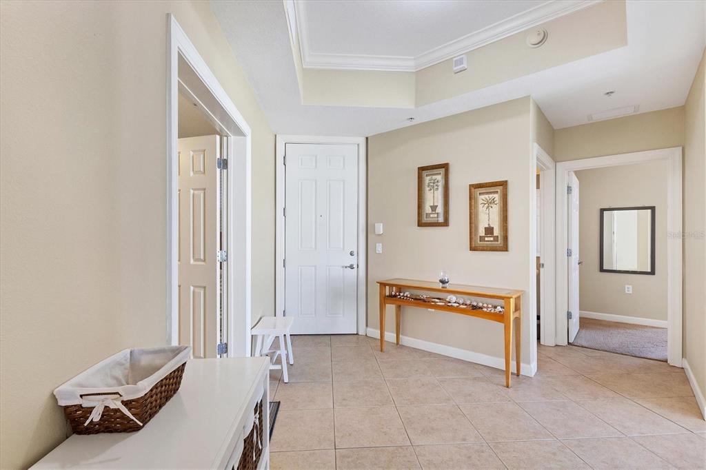 A tiled entryway features a console table, framed wall art, and doorways leading to other rooms — 8561 AMBERJACK CIRCLE UNIT 301, ENGLEWOOD, FL