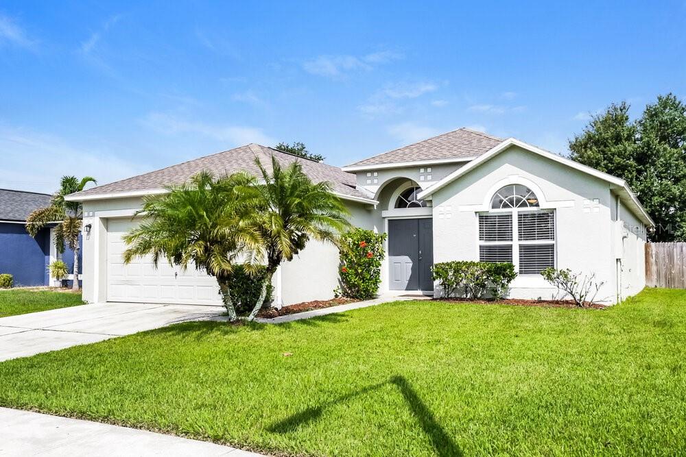 A single-story house with a two-car garage, a palm tree, and a arched window — 346 VITORIA ROAD, DAVENPORT, FL
