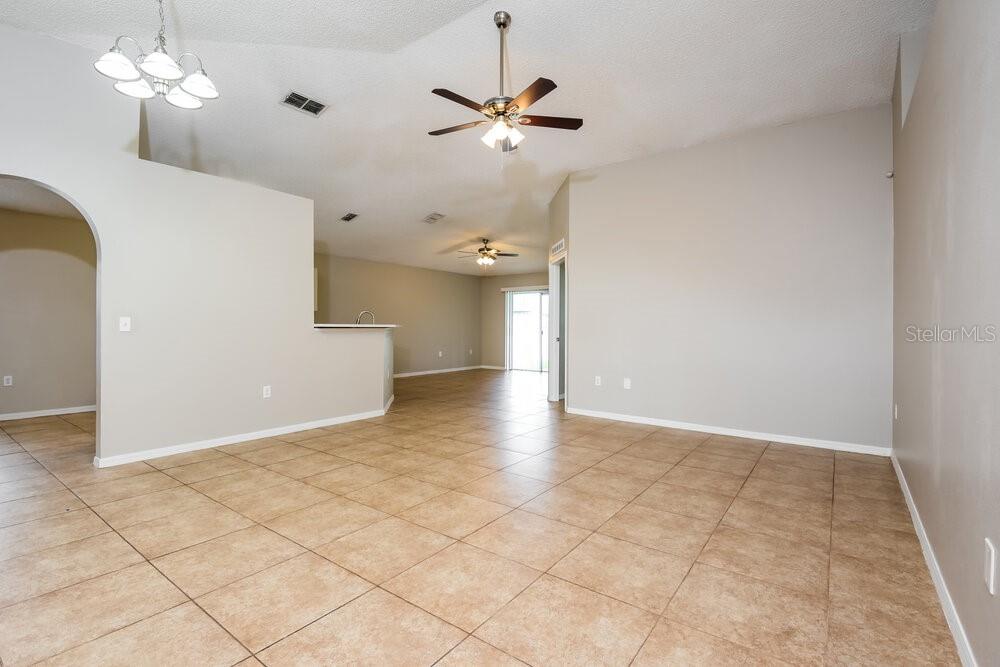 An open-concept living area features vaulted ceilings, tile flooring, and a kitchen breakfast bar — 346 VITORIA ROAD, DAVENPORT, FL