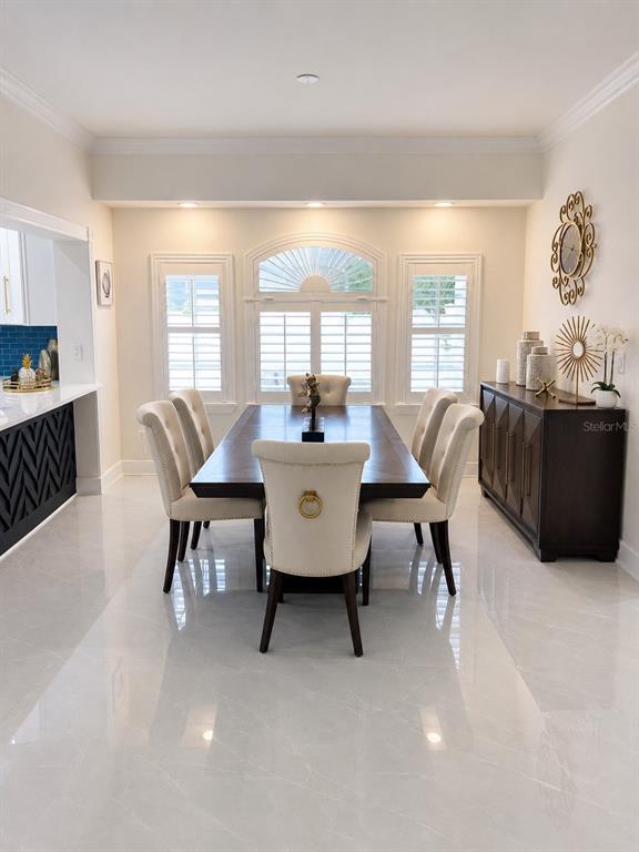A covered patio features a wooden bench, two wicker chairs, and a stone paver floor — 452 BATH CLUB BOULEVARD N, NORTH REDINGTON BEACH, FL