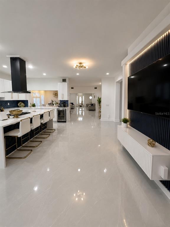 A bright entryway features light tile floors, a step-up transition, and a navy accent chair — 452 BATH CLUB BOULEVARD N, NORTH REDINGTON BEACH, FL