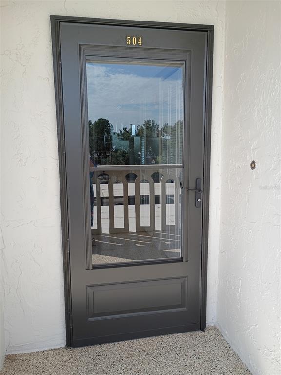 A dark-framed storm door with a glass panel and the number 504 installed on a balcony — 1776 6TH STREET NW UNIT 504, WINTER HAVEN, FL