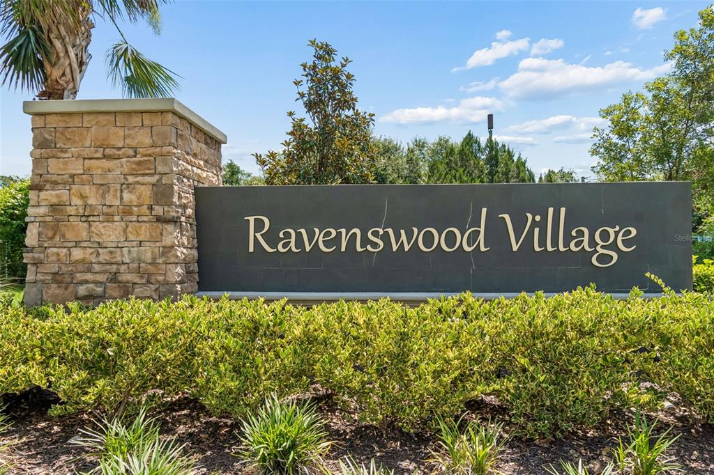 A stone-based monument sign for Ravenswood Village sits behind a manicured hedge — 153 ASHBROOK STREET, ST AUGUSTINE, FL