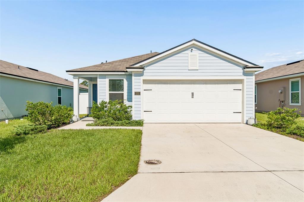 A light blue single-story house with a two-car garage and a concrete driveway — 153 ASHBROOK STREET, ST AUGUSTINE, FL