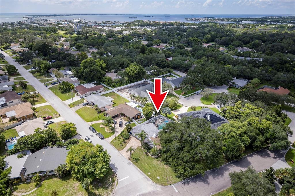 A covered outdoor patio features blue cushioned furniture, a small fountain, and a skylight — 1294 FAIRWAY DRIVE, DUNEDIN, FL