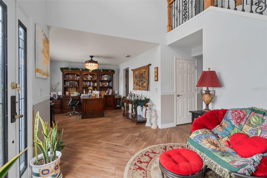 A foyer opens into a home office with a wooden desk, bookshelves, and tile flooring — 16017 LANESBORO COURT, CLERMONT, FL