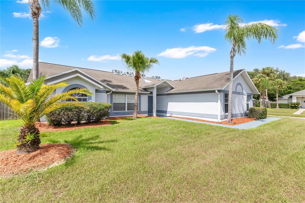 A single-story house with a gray and white exterior, palm trees, and a grassy lawn — 1097 DEPOT COURT, WINTER GARDEN, FL