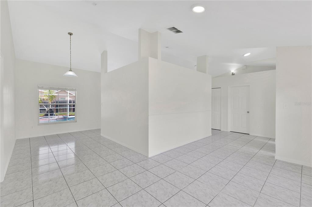 A bright, open-concept room features white walls, light-colored tile flooring, and a central partition wall — 1097 DEPOT COURT, WINTER GARDEN, FL