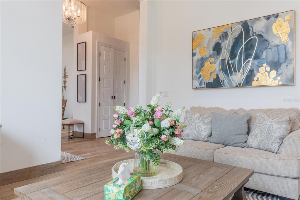 A living room features a beige sofa, a wooden coffee table, and abstract wall art — 2815 2815 DAIRY RD, MELBOURNE, FL