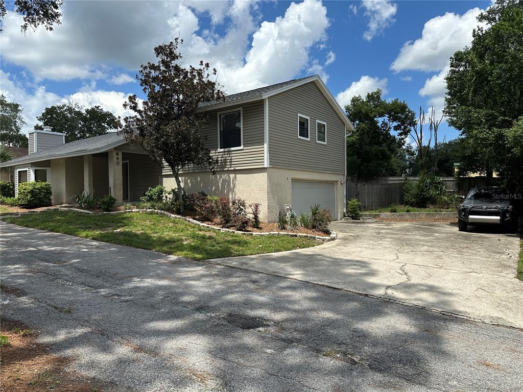A two-story house with beige siding and stucco features a concrete driveway and front lawn — 840 MARAVAL COURT, LONGWOOD, FL