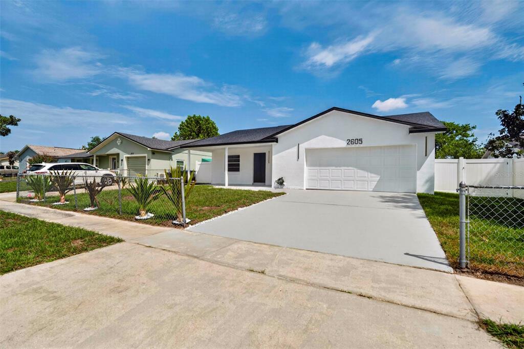 A white single-story house with a two-car garage and a concrete driveway — 2605 CHAR STREET, ORLANDO, FL