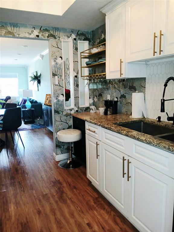 A kitchen features white cabinets, granite countertops, gold hardware, and patterned wallpaper with crane motifs — 1900 59TH AVENUE N UNIT 312, ST PETERSBURG, FL