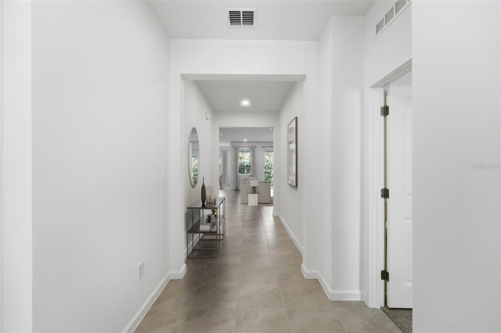 A bright hallway with light tile flooring leads toward an open living area — 324 FREE RANGE DRIVE, GROVELAND, FL