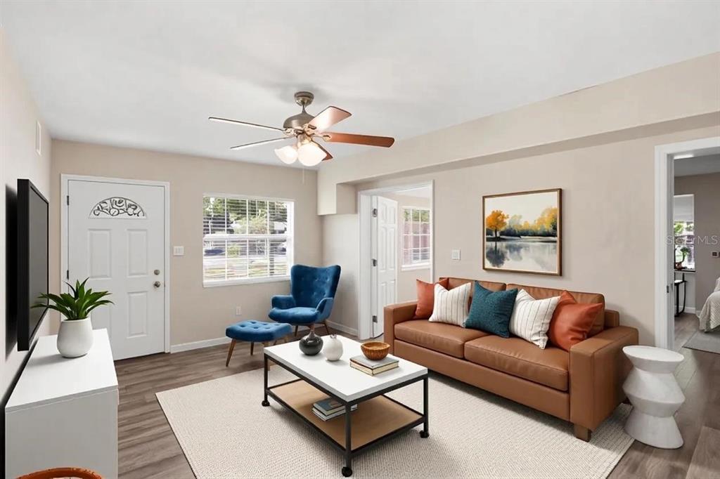 A living room with a brown sofa, blue armchair, white coffee table, and ceiling fan — 218 5TH JPV STREET, WINTER HAVEN, FL