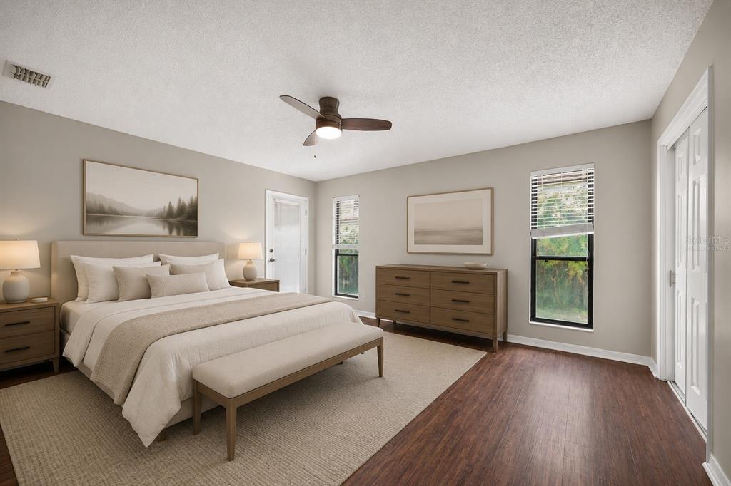 A bedroom with a king bed, wooden dresser, ceiling fan, and wood-look flooring — 3080 MARRANO DRIVE, ORANGE PARK, FL