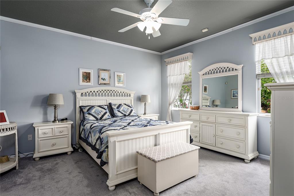 A bedroom features a white bed frame, matching dresser with mirror, and a ceiling fan — 3628 101ST AVENUE E, PARRISH, FL
