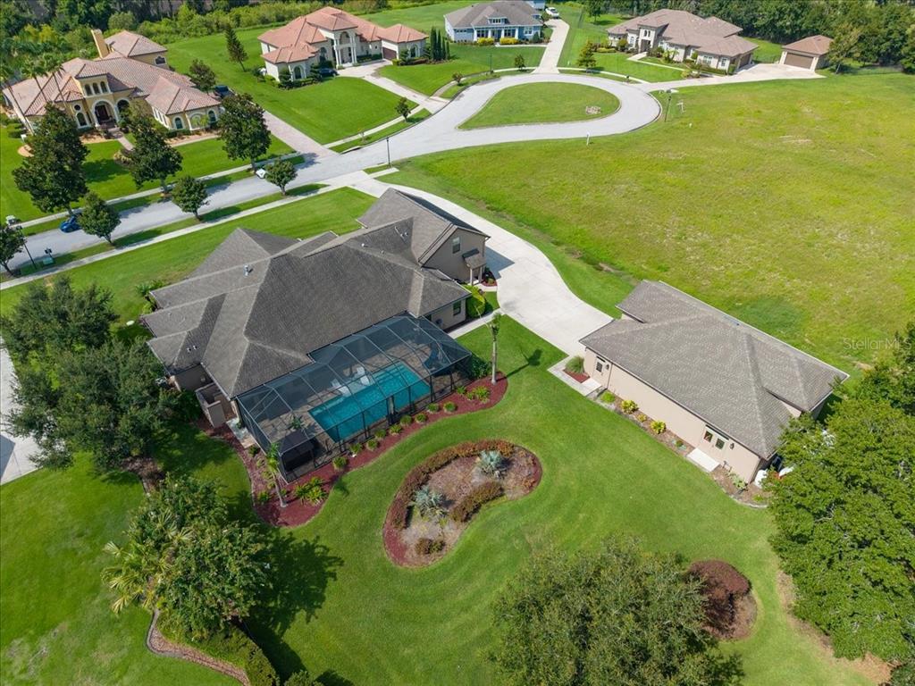 An aerial view shows a house with a screened pool and a detached garage — 408 HAWK TALON DRIVE, LITHIA, FL
