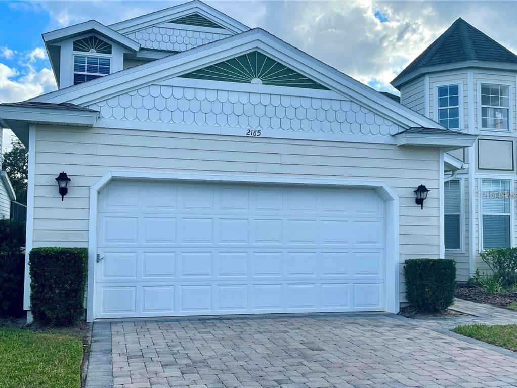 The exterior of a two-story house features a two-car garage and a paved driveway — 2185 VICTORIA DRIVE, DAVENPORT, FL