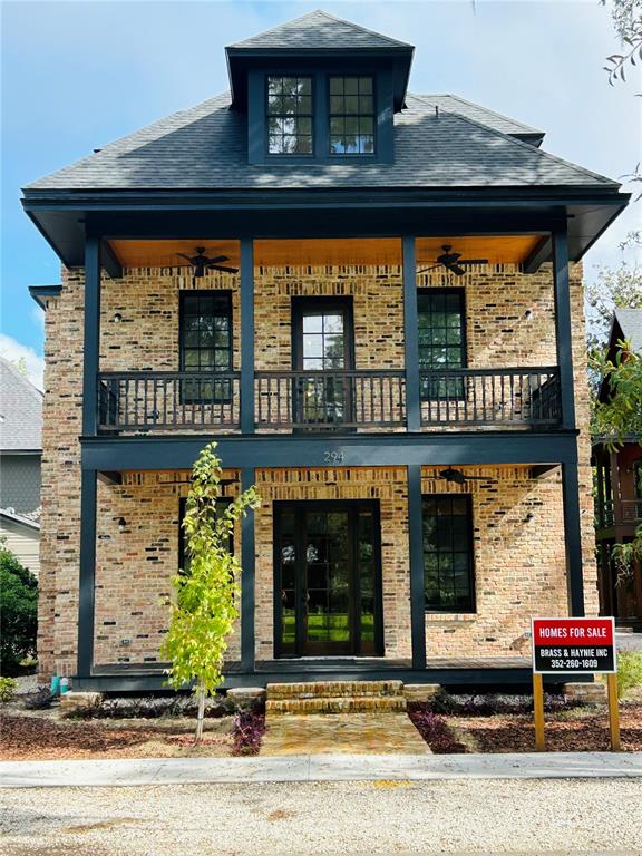 A two-story brick house features a dark-trimmed porch, a balcony, and a dormer window — 294 NW 12TH AVENUE, GAINESVILLE, FL