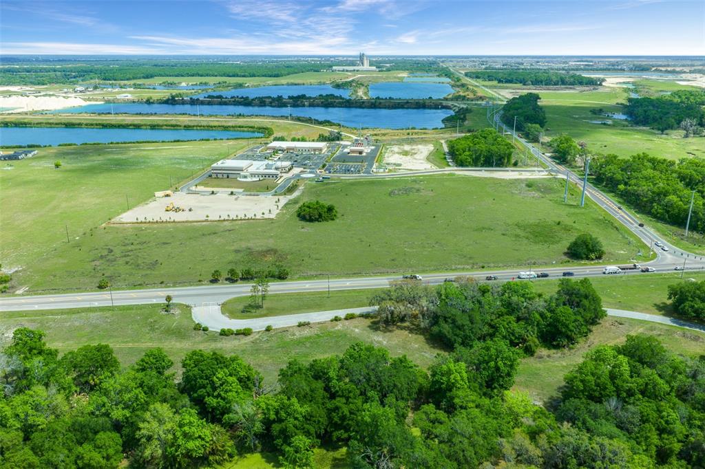 An aerial view shows a large commercial building surrounded by open fields, ponds, and roads — 178 N US 301, SUMTERVILLE, FL