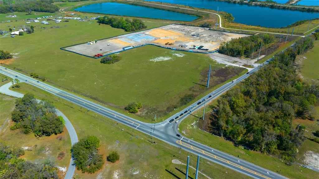 An aerial view shows a large, cleared construction site adjacent to a road and ponds — 178 N US 301, SUMTERVILLE, FL