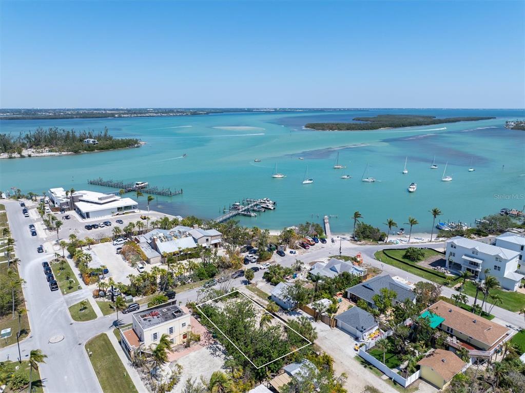 An aerial view shows a vacant rectangular lot near a coastal bay with boats — 6981 LOIS AVENUE, LONGBOAT KEY, FL