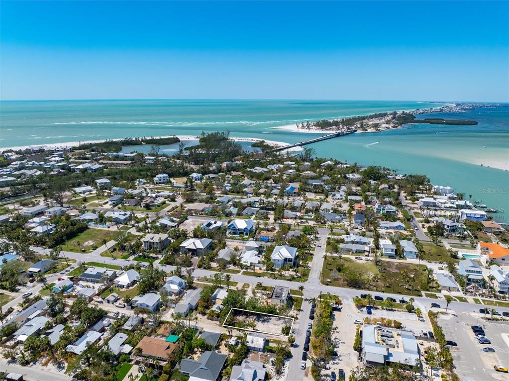 An aerial view shows a vacant rectangular lot in a coastal residential neighborhood near water — 6981 LOIS AVENUE, LONGBOAT KEY, FL