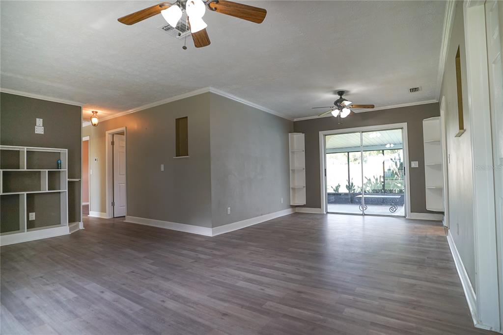 An interior view of a living room featuring large tan floor tiles and two ceiling fans — 3320 LAS BRISAS DRIVE, RIVERVIEW, FL