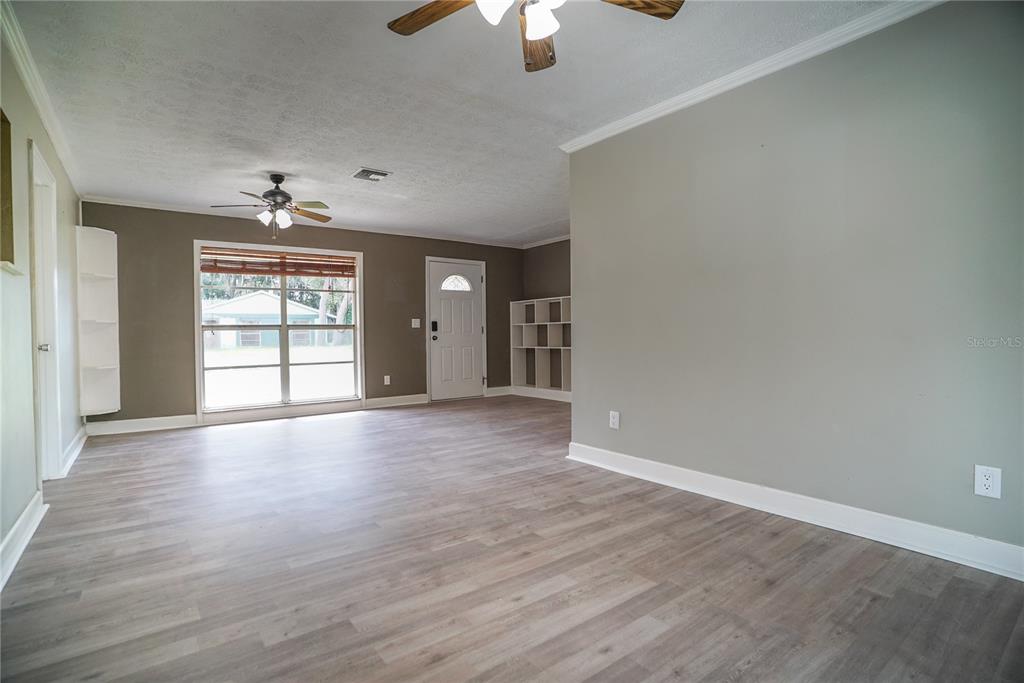 An empty bedroom features tan walls, a ceiling fan, and a stained concrete floor — 3320 LAS BRISAS DRIVE, RIVERVIEW, FL