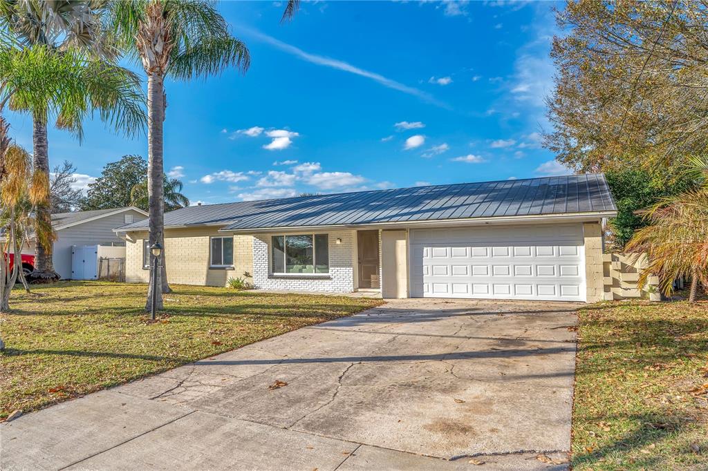 A single-story house with a metal roof, brick facade, and a two-car garage — 2801 GULFSTREAM ROAD, ORLANDO, FL