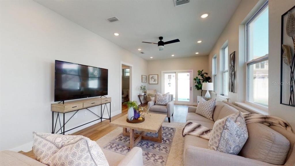 A living room features a television on a console, a sofa, and a coffee table — 5113 12TH AVENUE N, ST PETERSBURG, FL