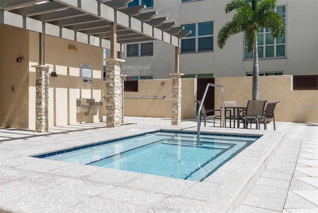 A square hot tub sits on a tiled patio beneath a wooden pergola — 1238 E KENNEDY BOULEVARD UNIT 501, TAMPA, FL