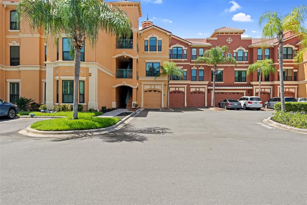 A yellow Mediterranean-style house with a red tile roof and palm trees in the front — 2717 VIA CIPRIANI UNIT 631A, CLEARWATER, FL