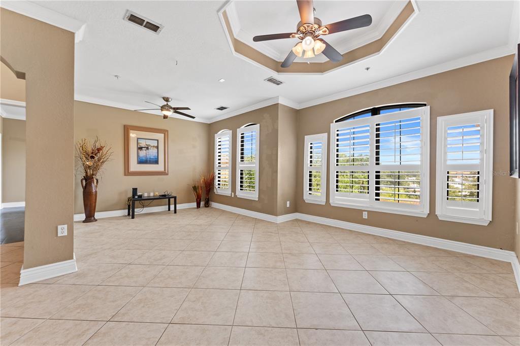 An empty dining area features tan walls, a ceiling fan, and light-colored tile flooring — 2717 VIA CIPRIANI UNIT 631A, CLEARWATER, FL