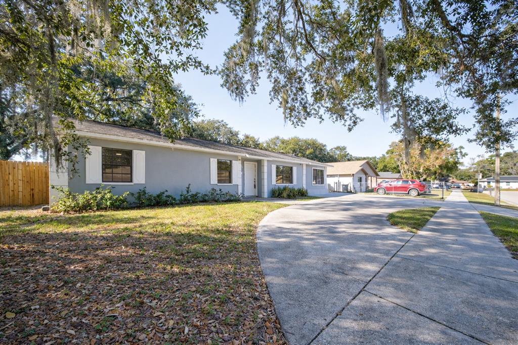 An aerial view shows a single-story house with a gray roof, driveway, and backyard sheds — 720 SWISS DRIVE, LAKELAND, FL
