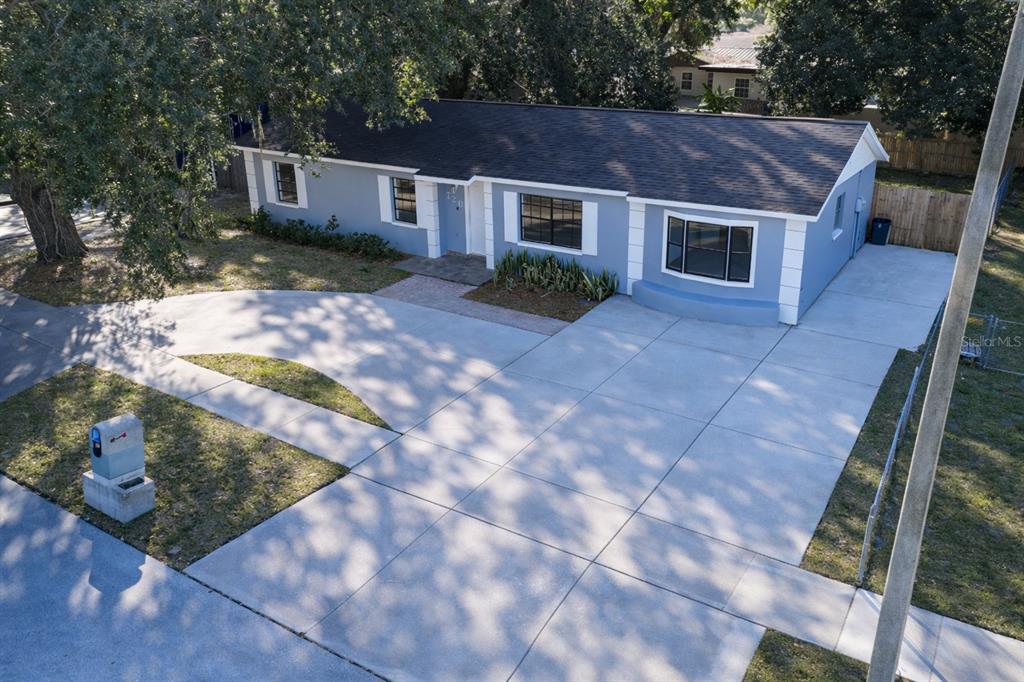 A bright, open-concept kitchen and dining area featuring white cabinetry, stainless steel appliances, and wood-look flooring — 720 SWISS DRIVE, LAKELAND, FL