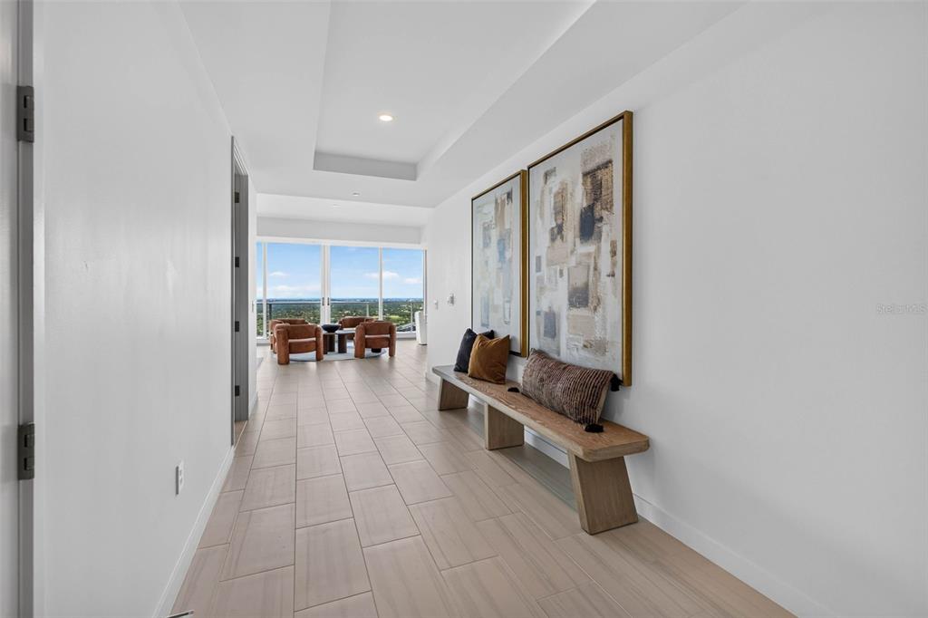 An open-concept living area features light tile flooring, white walls, and floor-to-ceiling windows — 400 CENTRAL AVENUE UNIT 3401, ST PETERSBURG, FL