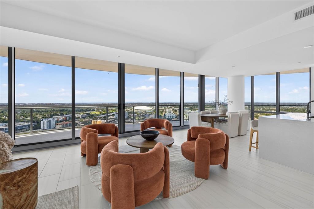 A modern kitchen with white cabinets and a center island opens into a spacious living area — 400 CENTRAL AVENUE UNIT 3401, ST PETERSBURG, FL