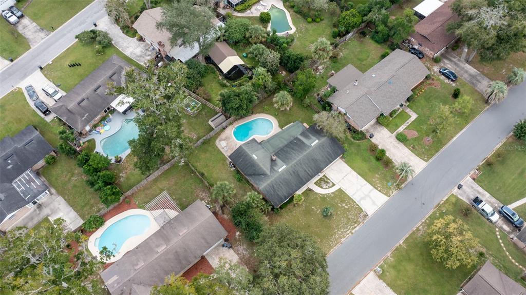 An aerial view shows several suburban houses with swimming pools and driveways on a street — 3442 RED OAK CIRCLE E, ORANGE PARK, FL