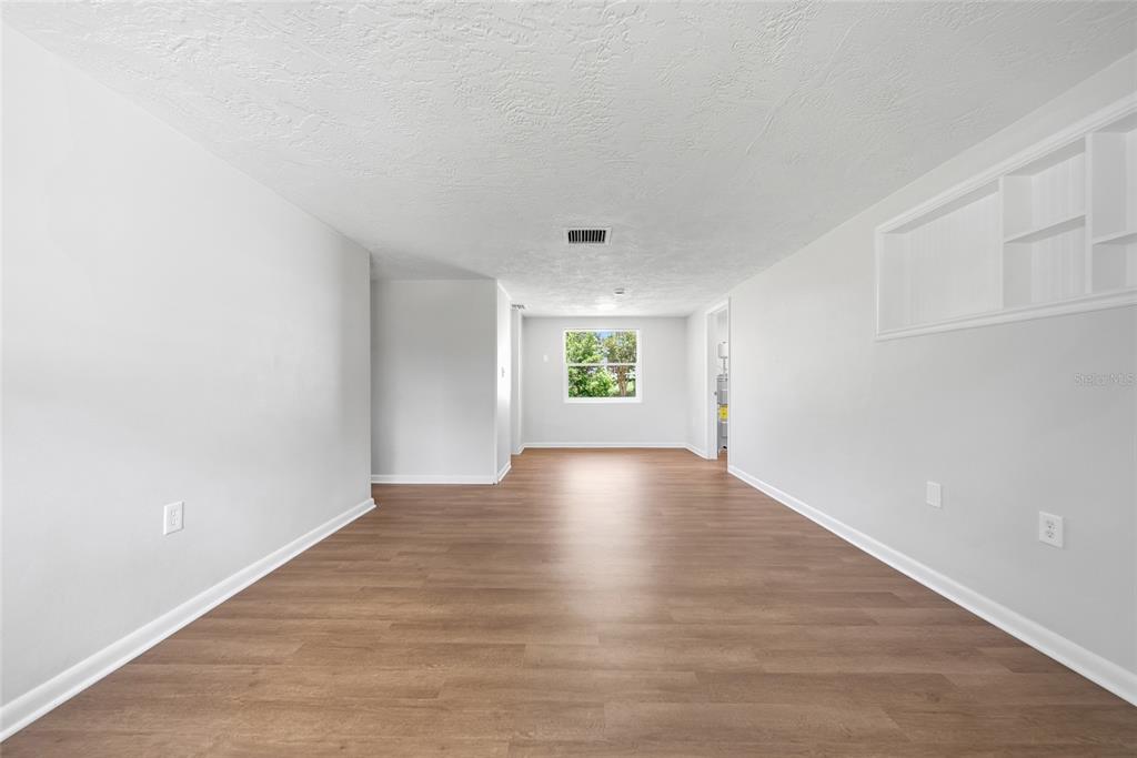 An empty room with light gray walls, wood-look flooring, and built-in white shelving — 52 S JEFFERSON STREET, BEVERLY HILLS, FL