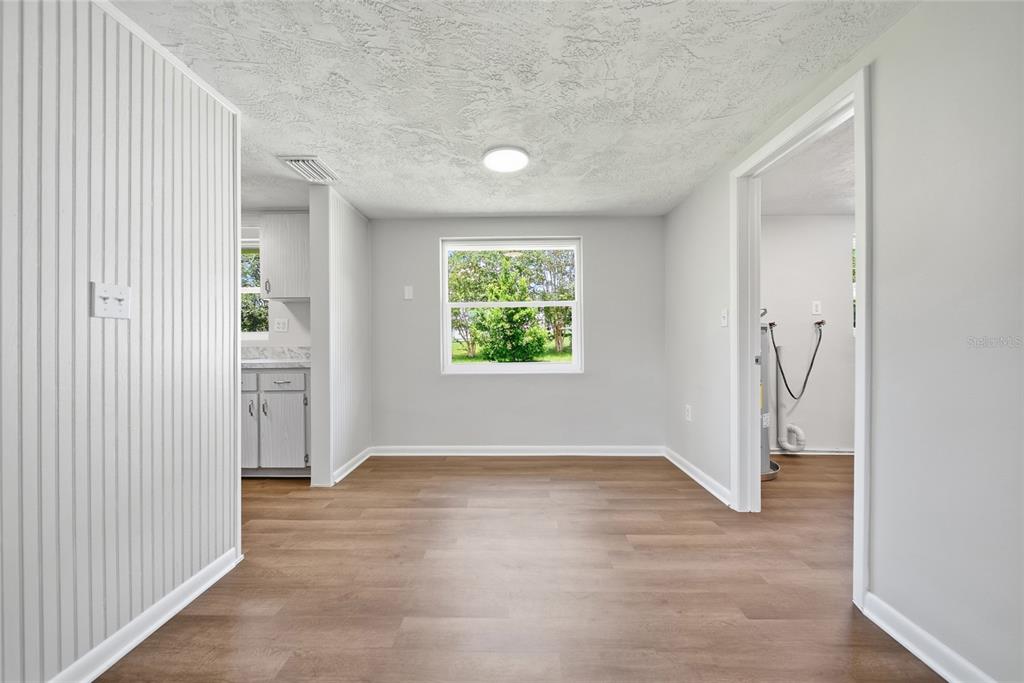 An empty dining area features light gray walls, wood-look flooring, and a window facing outdoors — 52 S JEFFERSON STREET, BEVERLY HILLS, FL