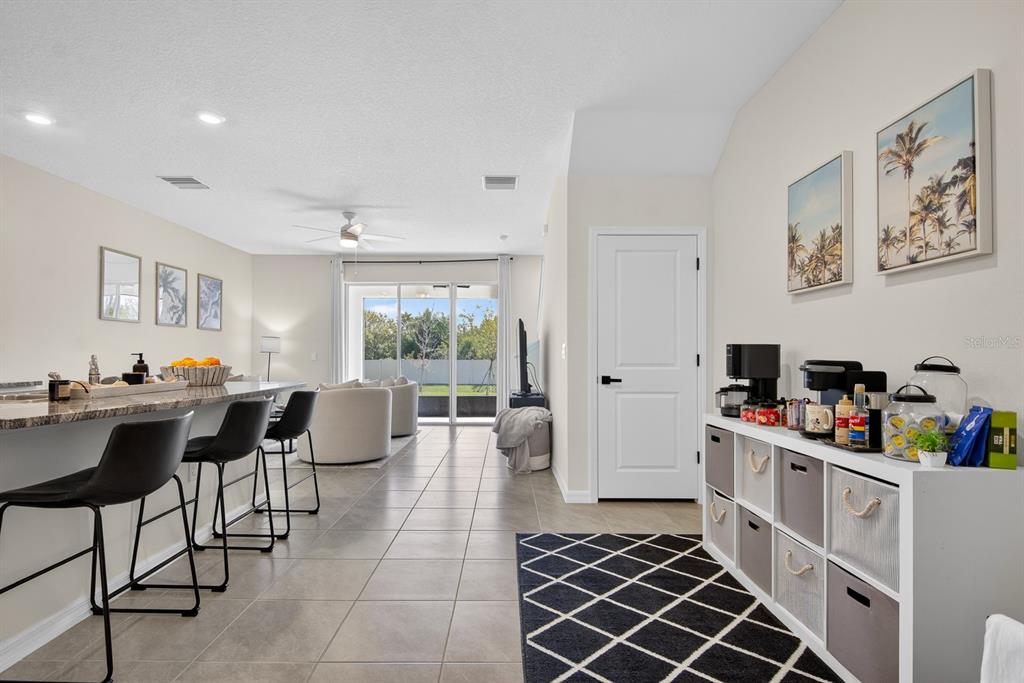 A kitchen with a breakfast bar and a coffee station leads to a living area — 350 MANGROVE SHADE CIRCLE, APOLLO BEACH, FL